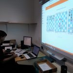 Adam Raoof in arbiter office of Southend Congress 2019, big screen shows top 3 boards.