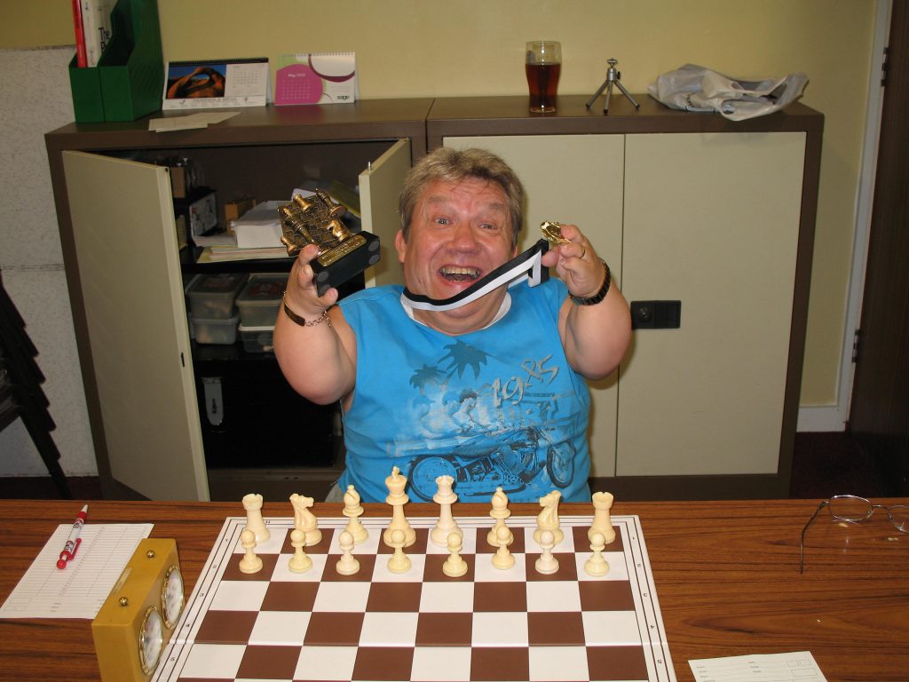 Mike Henbury holding chess trophy and medal