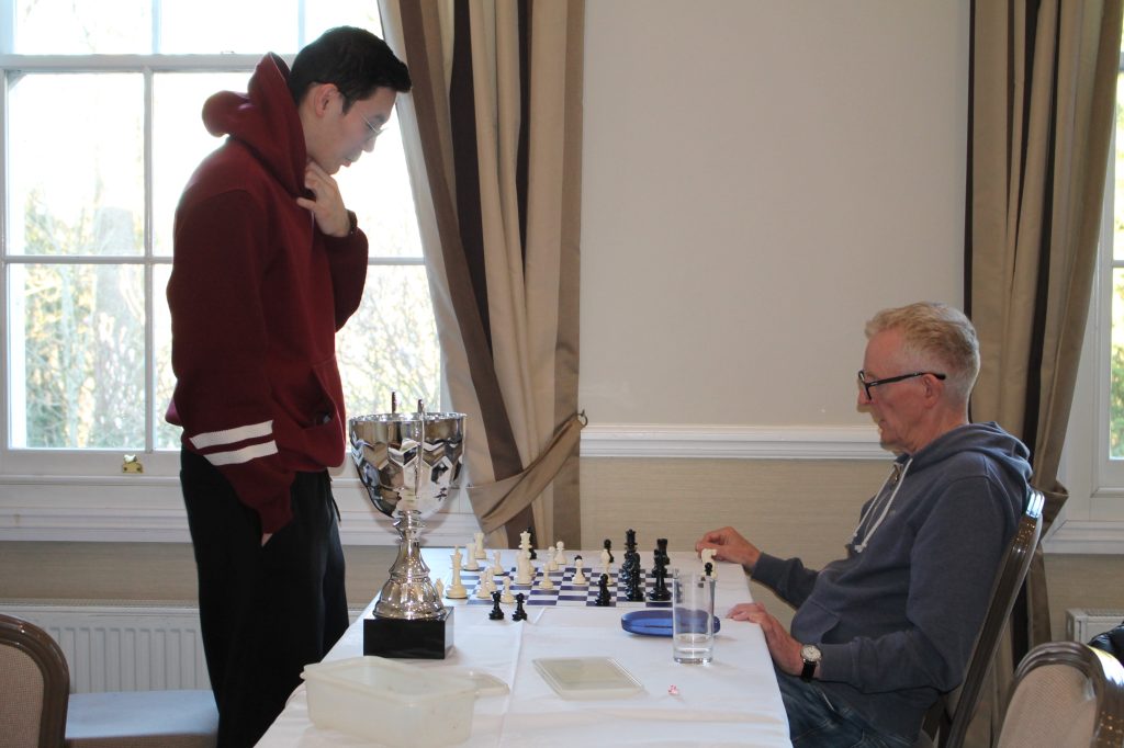 Chandlers Ford players Alikhan Menseitov (standing next to big trophy) and Dave Holmes deep in analysis